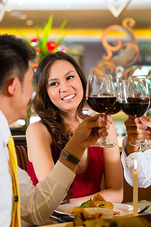 Image of well-to-do couple toasting with wine in restaurant